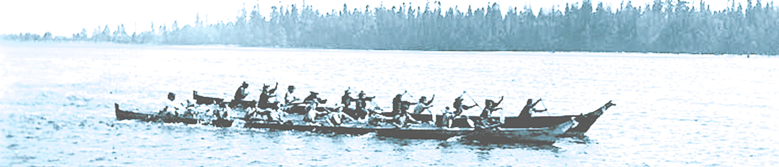 Large handcarved Tulalip canoes with tribal people paddling in the Tulalip Bay.